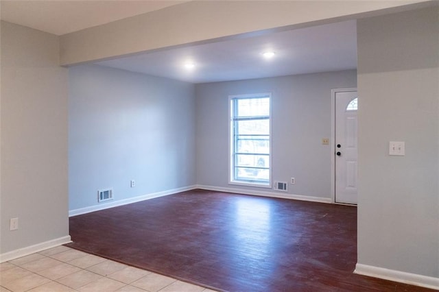 spare room with wood finished floors, baseboards, and visible vents