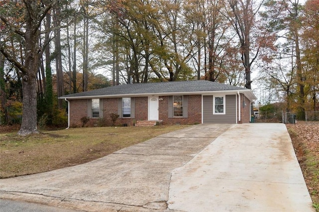 single story home featuring brick siding, concrete driveway, and a front yard