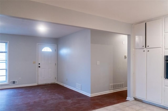 foyer entrance with visible vents, baseboards, and light wood finished floors