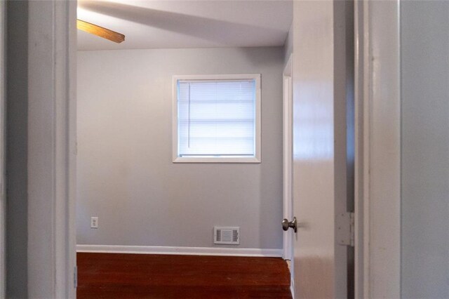 unfurnished room with wood finished floors, visible vents, and baseboards