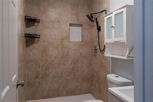 bathroom featuring vanity, toilet, and tiled shower