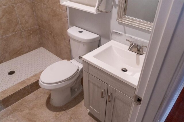 bathroom featuring toilet, a stall shower, and vanity