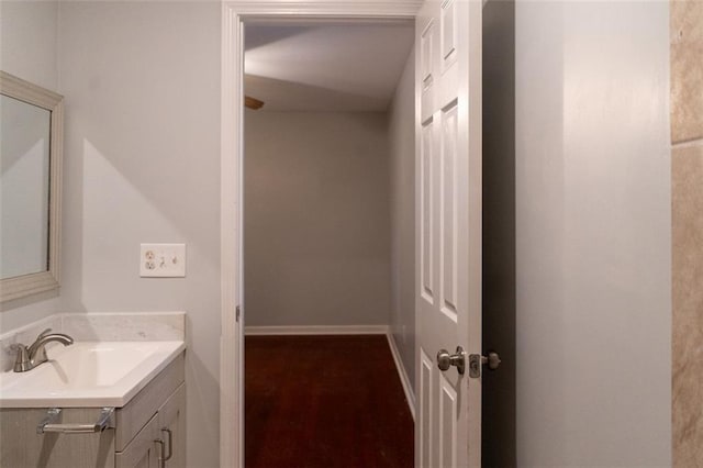 bathroom with vanity, baseboards, and wood finished floors