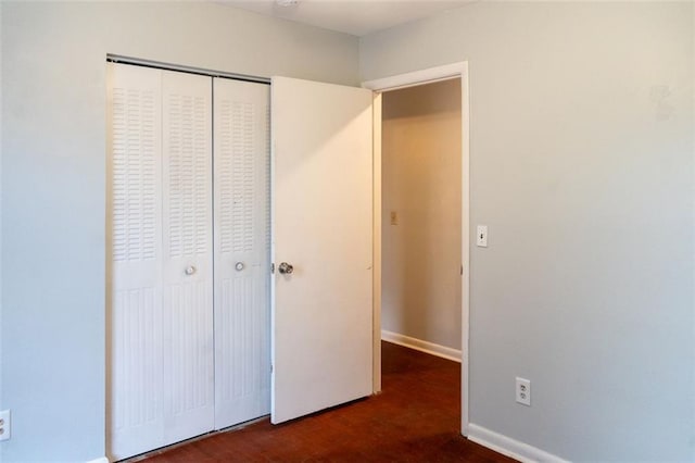 unfurnished bedroom with baseboards and a closet