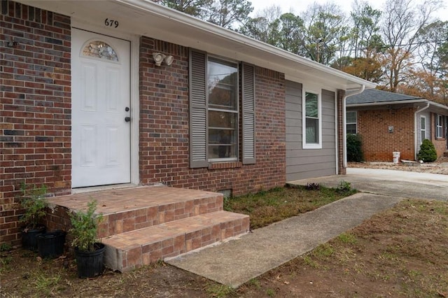 view of exterior entry featuring brick siding