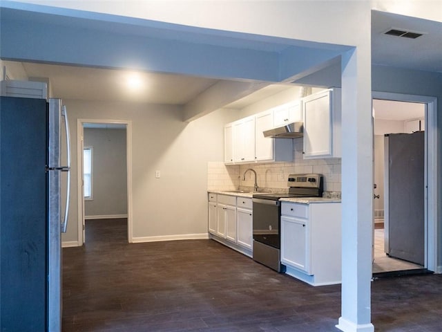 kitchen featuring visible vents, light countertops, under cabinet range hood, appliances with stainless steel finishes, and tasteful backsplash