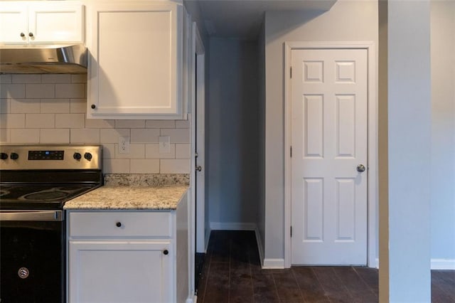 kitchen featuring under cabinet range hood, white cabinetry, tasteful backsplash, and stainless steel range with electric cooktop