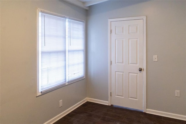 unfurnished room with dark wood-style floors and baseboards