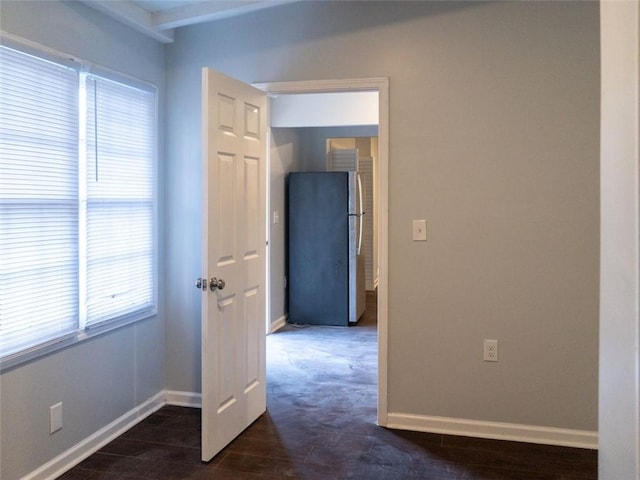 empty room with dark wood finished floors and baseboards