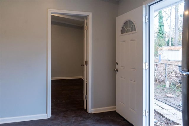 foyer entrance with dark wood finished floors and baseboards