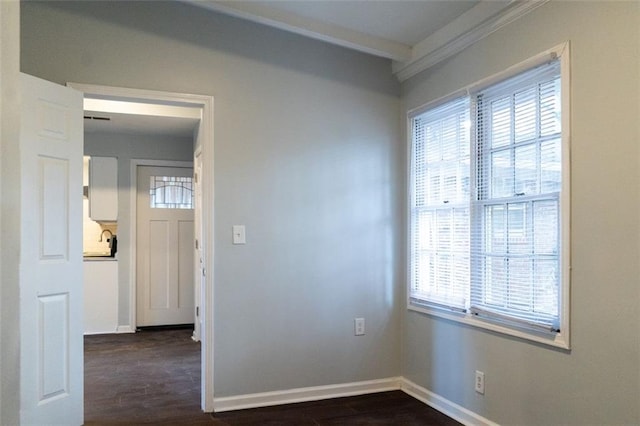 spare room featuring dark wood finished floors and baseboards