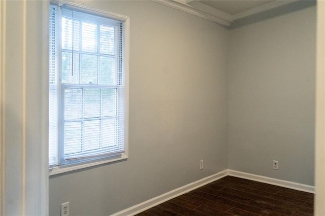 empty room featuring ornamental molding, baseboards, and dark wood-style flooring