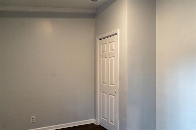 spare room featuring dark wood finished floors and baseboards