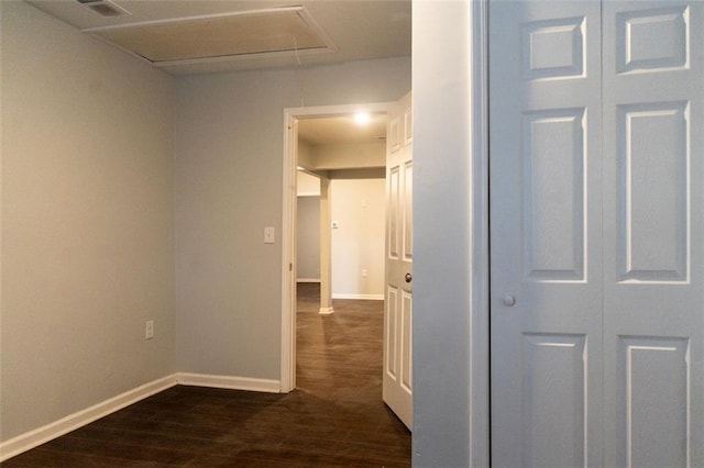 hall with attic access, dark wood-style floors, baseboards, and visible vents