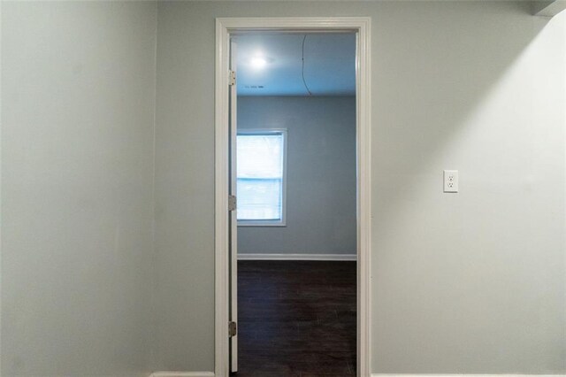 hallway featuring baseboards and wood finished floors