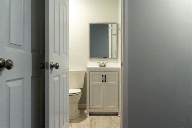 bathroom featuring marble finish floor, toilet, and vanity