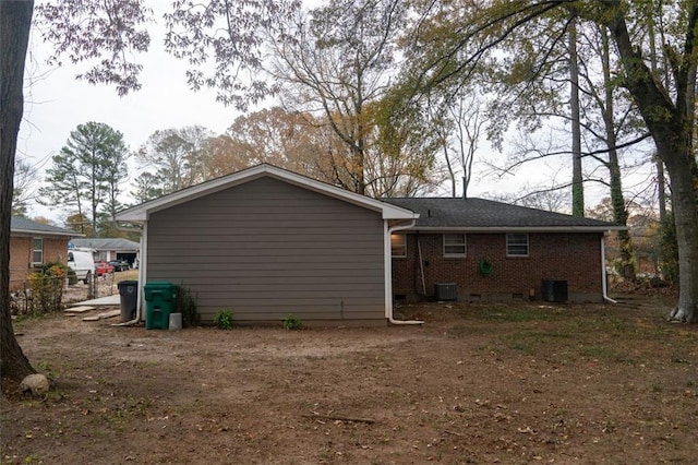 rear view of house with cooling unit, fence, and brick siding