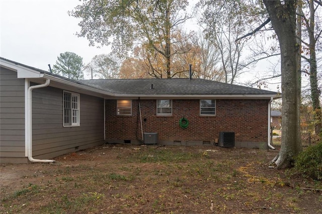 rear view of house featuring crawl space, central air condition unit, and brick siding