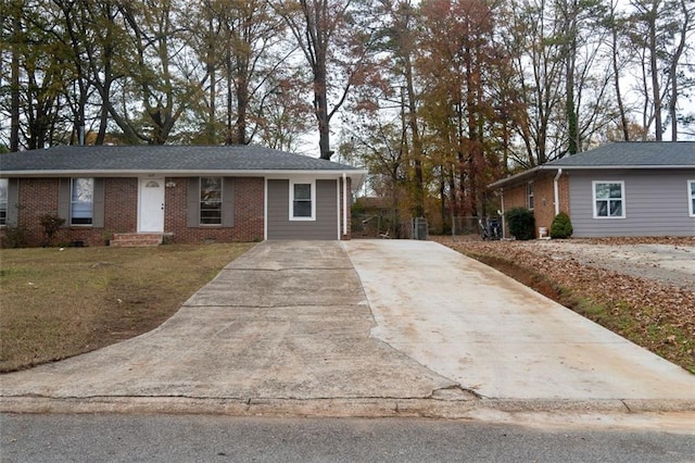 ranch-style house featuring a front lawn, brick siding, and driveway