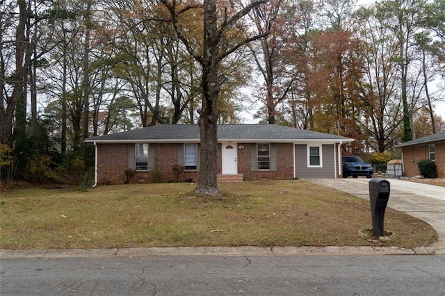 single story home featuring concrete driveway, brick siding, and a front yard