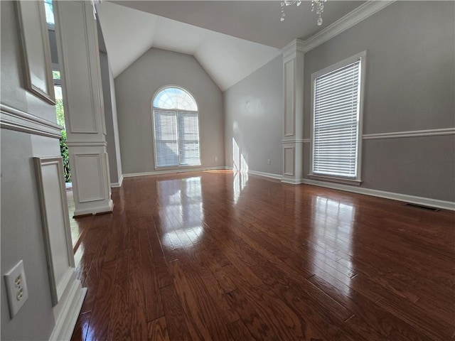 3773 Summer Rose Dr, Atlanta, GA 30341 - unfurnished living room featuring ornate columns, dark wood-style floors, baseboards, and vaulted ceiling