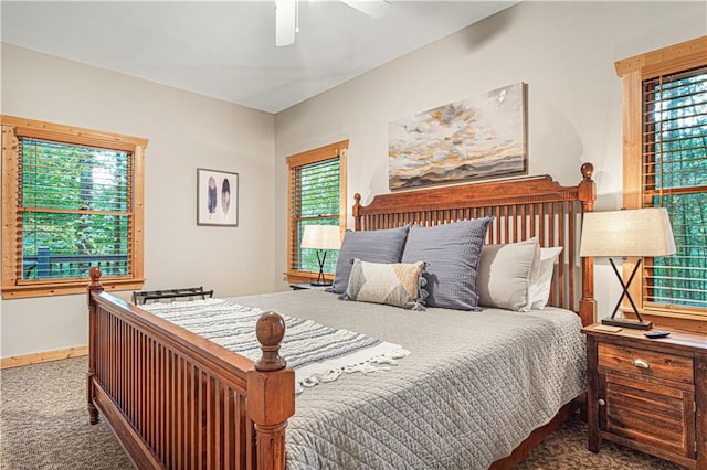 carpeted bedroom featuring baseboards, multiple windows, and a ceiling fan