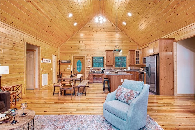 living room featuring wood walls, wooden ceiling, high vaulted ceiling, and light wood-type flooring