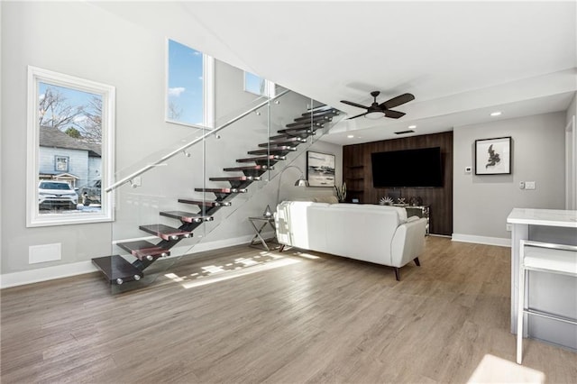 unfurnished living room featuring ceiling fan and light wood-type flooring