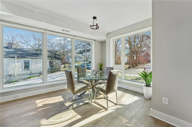 sunroom featuring a notable chandelier and a healthy amount of sunlight