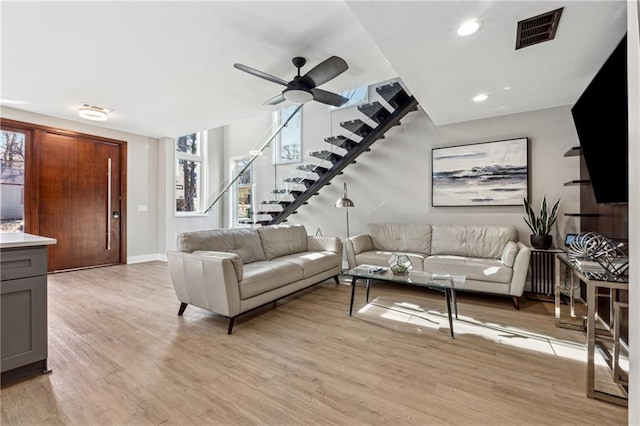 living room featuring ceiling fan and light wood-type flooring