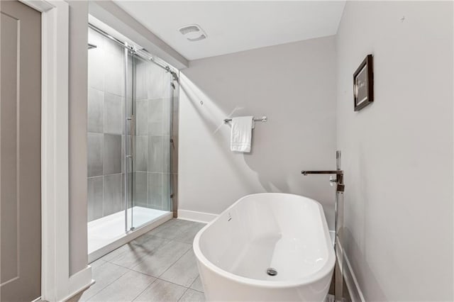 bathroom featuring tile patterned floors and separate shower and tub