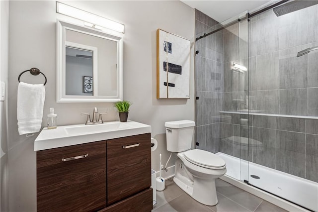 bathroom featuring tile patterned floors, vanity, toilet, and a shower with door