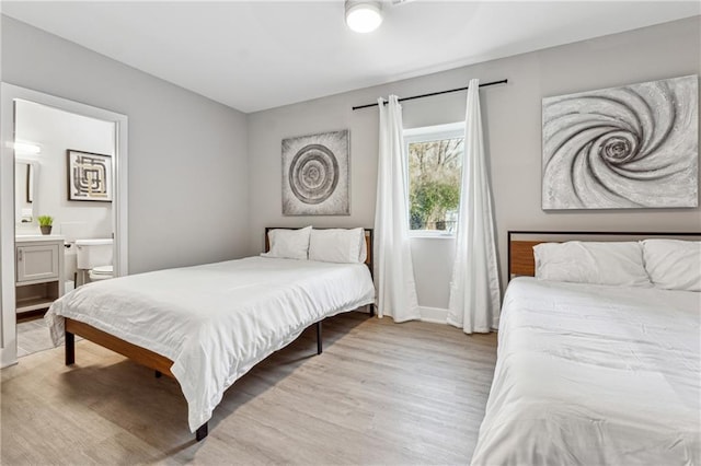 bedroom featuring light hardwood / wood-style flooring and ensuite bathroom