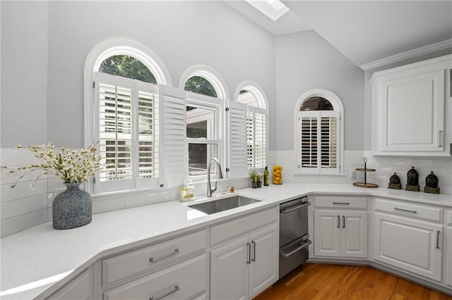 14270 Morning Mountain Way, Milton, GA 30004 - kitchen featuring backsplash, a skylight, white cabinetry, stainless steel dishwasher, and light wood-style flooring