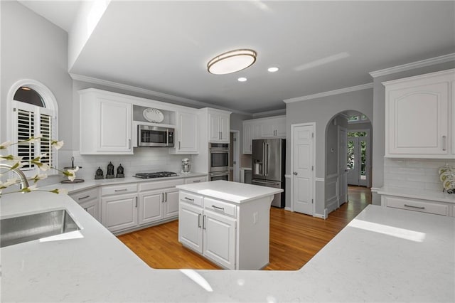 14270 Morning Mountain Way, Milton, GA 30004 - kitchen featuring appliances with stainless steel finishes, arched walkways, recessed lighting, crown molding, and white cabinets