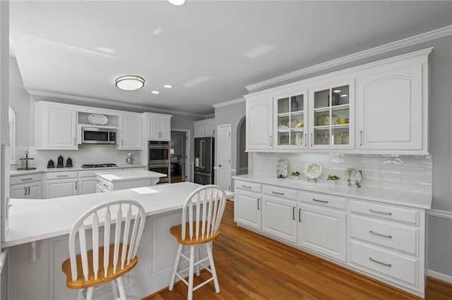 14270 Morning Mountain Way, Milton, GA 30004 - kitchen with appliances with stainless steel finishes, backsplash, a kitchen bar, white cabinets, and ornamental molding