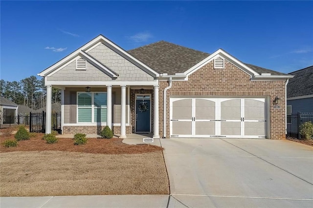 craftsman house with a garage, brick siding, driveway, and fence