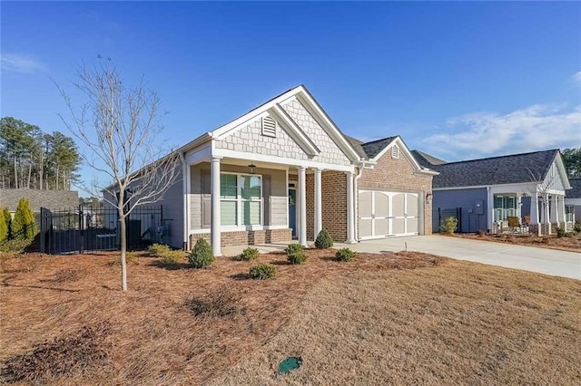 craftsman house featuring a garage, fence, brick siding, and driveway