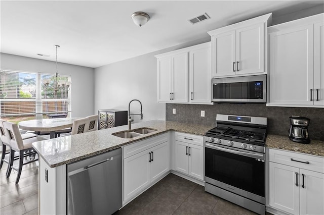 133 Worthing Ln, Fairburn, GA 30213 - kitchen featuring stainless steel appliances, a chandelier, a peninsula, dark tile patterned floors, and white cabinets