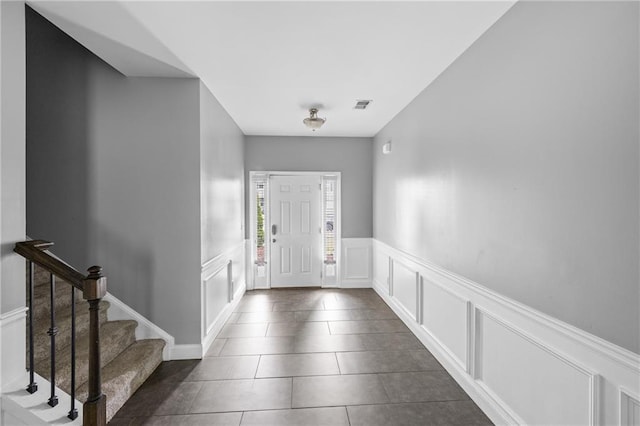 133 Worthing Ln, Fairburn, GA 30213 - foyer entrance with a decorative wall, a wainscoted wall, dark tile patterned floors, and stairway