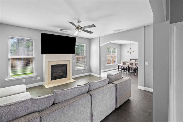 133 Worthing Ln, Fairburn, GA 30213 - living room with healthy amount of natural light, a chandelier, arched walkways, and dark tile patterned flooring