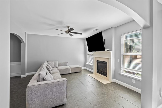 133 Worthing Ln, Fairburn, GA 30213 - living area featuring arched walkways, ceiling fan, a fireplace with flush hearth, and tile patterned flooring
