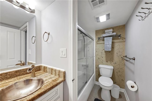 full bathroom featuring enclosed tub / shower combo, vanity, and toilet