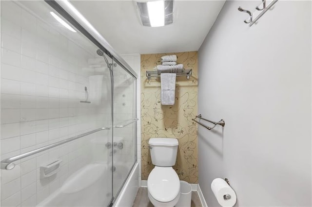 bathroom featuring toilet and enclosed tub / shower combo