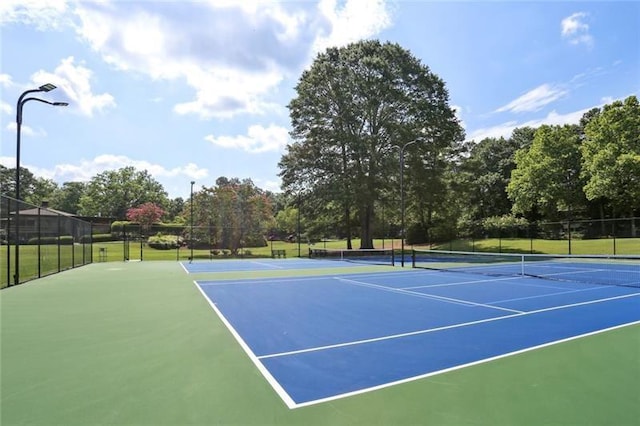 view of tennis court with basketball hoop