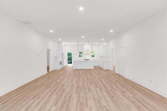 614 Glendale Rd, Scottdale, GA 30079 - unfurnished living room with recessed lighting, light wood-type flooring, and baseboards