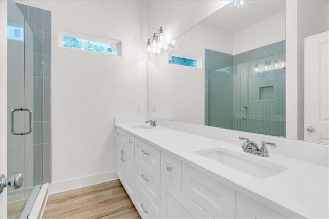 614 Glendale Rd, Scottdale, GA 30079 - bathroom with double vanity, a stall shower, wood finished floors, and baseboards