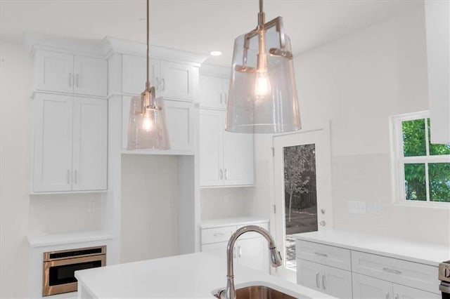 614 Glendale Rd, Scottdale, GA 30079 - kitchen featuring white cabinets, light countertops, and decorative light fixtures