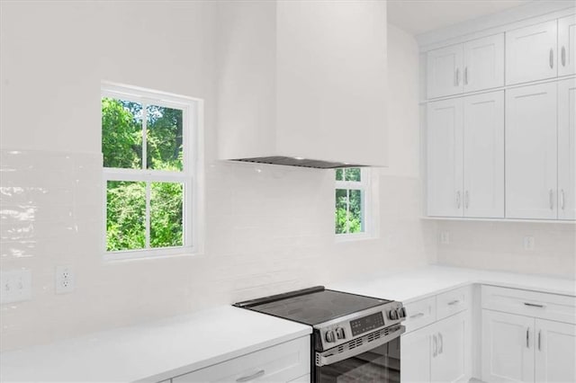 614 Glendale Rd, Scottdale, GA 30079 - kitchen featuring stainless steel range with electric stovetop, light countertops, healthy amount of natural light, and white cabinetry