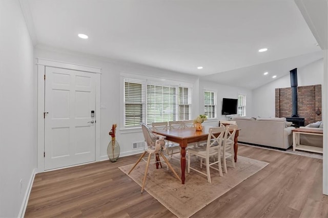 597 Rich Davis Rd, Hiram, GA 30141 - dining space featuring a wood stove, light wood-style flooring, baseboards, lofted ceiling, and recessed lighting